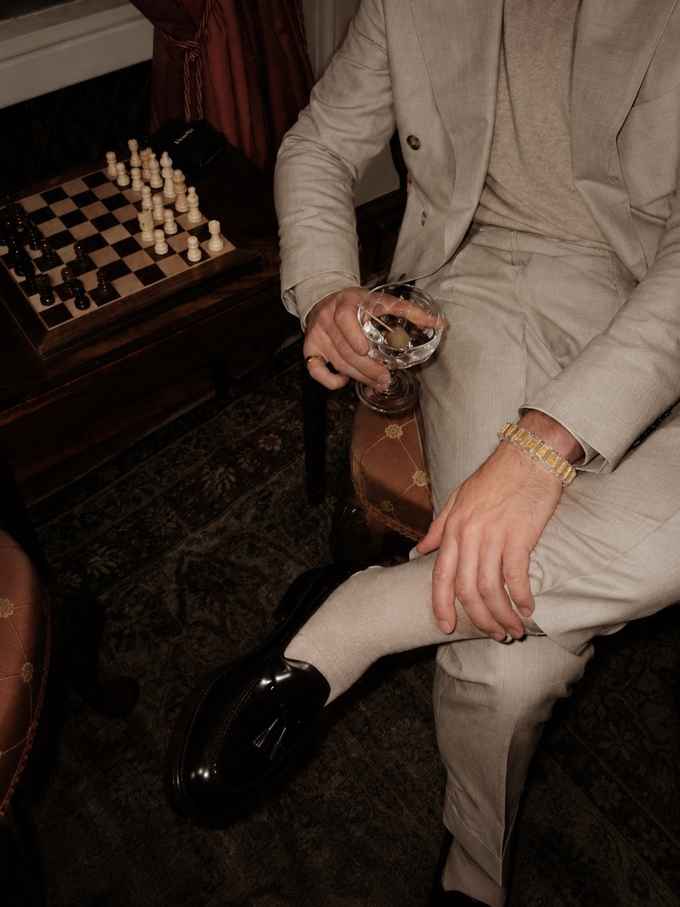 Bracelet worn on the wrist of a man seated beside a chess board